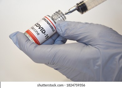 Doctor holding a syringe and a vial with Covid-19 virus vaccine. Pharmaceutical research against Coronavirus, concept.