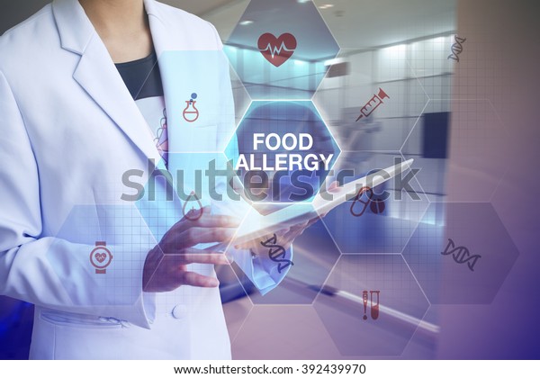 Doctor holding\
tablet with FOOD ALLERGY   text and working with modern computer\
interface , E-Health concept\

