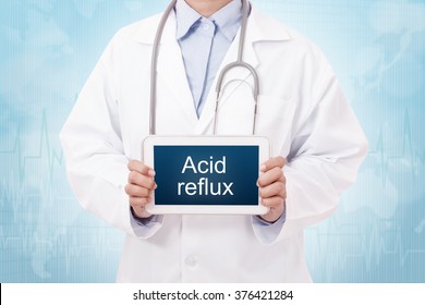 Doctor Holding A Tablet Pc With Acid Reflux Sign On Blue Background