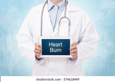 Doctor Holding A Tablet Pc With Heartburn Sign On Blue Background