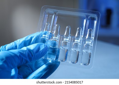 Doctor Holding Tray With Ampoules On Blurred Background, Closeup