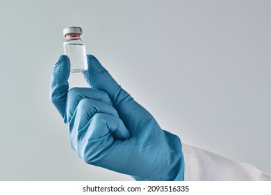 Doctor holding vaccine vial, close up of hand with selective focus