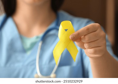 Doctor holding yellow ribbon, closeup. Sarcoma concept. - Powered by Shutterstock