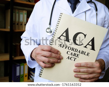 Doctor holds a book Affordable care act ACA. Imagine de stoc © 