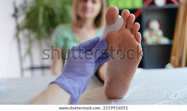 Doctor holds brace for hallux valgus. Pain in\
toes can caused by broken bone tendinitis sprain gout arthritis or\
bone disease concept