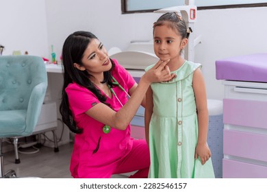 Doctor holds the head of a girl while she is measuring her height - Powered by Shutterstock