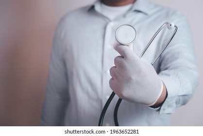 Doctor holds his stethoscope to insinuate that it's time for a check up, professional emergency healthcare assistance service concept. - Shutterstock ID 1963652281
