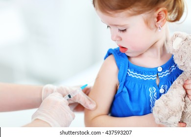 Doctor Holds An Injection Vaccination The Child
