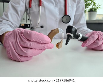 Doctor Holds Medical Instruments For ENT Doctor And Hearing Aid. Otolaryngologist Tool Kit And Hearing Aids