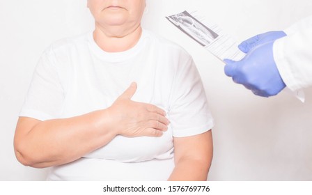 The Doctor Holds The Results Of An Examination Of An Elderly Woman Who Has Heart Problems. Cardiovascular Disease Concept, Ischemia And Angina Pectoris, Medical