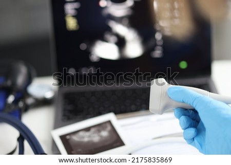Doctor holds ultrasonic probe in hand preparing device for examination