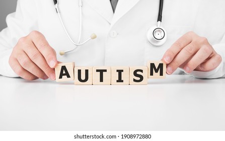 Doctor Holds Wooden Cubes In His Hands With Text AUTISM