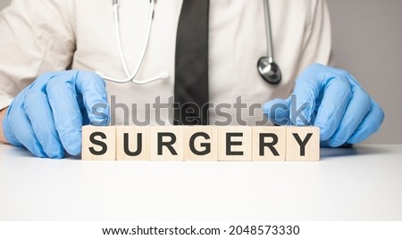 Doctor holds wooden cubes in his hands with text surgery