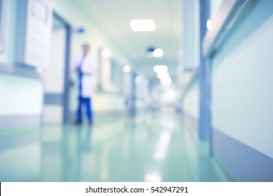 Doctor in hospital corridor, unfocused background.