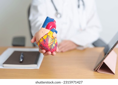 Doctor with human Heart anatomy model and tablet. Cardiovascular Diseases, Atherosclerosis, Hypertensive Heart, Valvular Heart, Aortopulmonary window, world Heart day and health concept