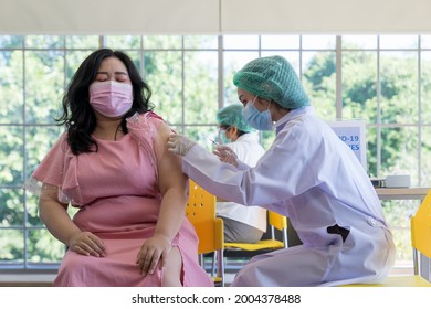 Doctor Injecting Covid-19 Vaccine Into A Fat Woman In The Hospital To Prevent Of Coronavirus. Immunization, Vaccination Clinic, Obesity Paradox In Infections And Implications For COVID-19 Vaccine.
