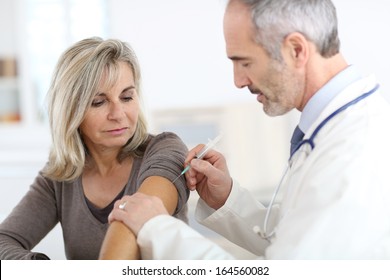 Doctor Injecting Vaccine To Senior Woman