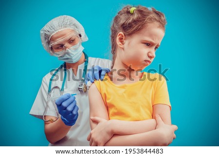 The doctor injects a little girl an intramuscular injection of the vaccine into her shoulder. Child vaccination immunization concept. Vaccination of the child. An injection. Selective focus children.