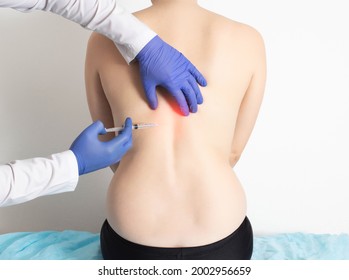 The doctor injects an ozone-oxygen mixture into the back of a girl to a patient to treat diseases of the spine and relax the muscles of the back. Modern method of ozone therapy - Shutterstock ID 2002956659
