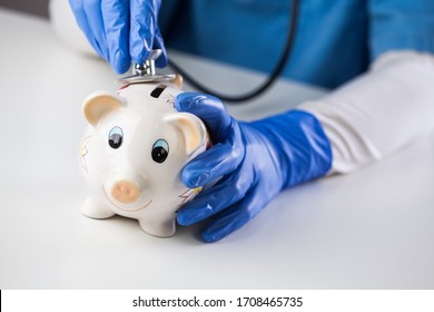 Doctor Inspecting Piggy Bank With Stethoscope, Economy Recession Due To Global COVID-19 Coronavirus World Pandemic Outbreak,financial Hardship & Uncertain Future,health Care,life Savings & Insurance