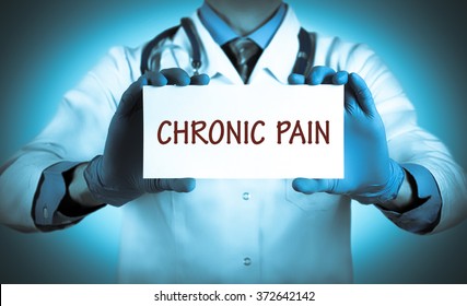 Doctor keeps a card with the name of the diagnosis -?? chronic pain. Selective focus. Medical concept.
