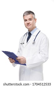 Doctor In Lab Coat And Stethoscope Holding A Patient File Or Medical Notes On A Clipboard In His Hands As He Turns To Look At The Camera Isolated On White