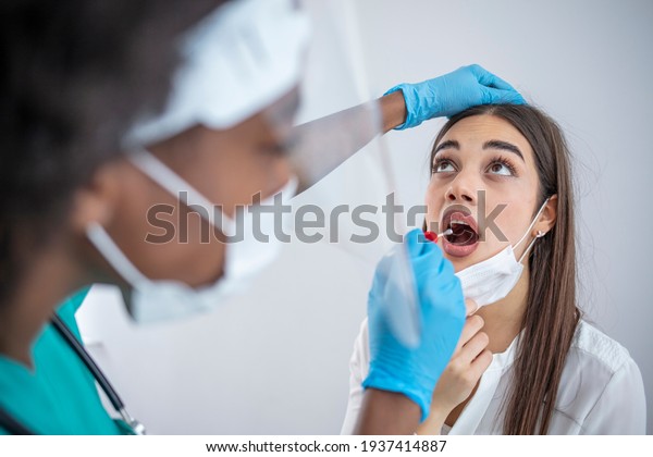 Doctor laboratory assistant in protective suit
takes swab  of sick patient. Laboratory tests for coronavirus
concept. Close-up of healthcare worker taking PCR test at medical
clinic.