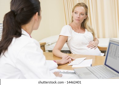 Doctor With Laptop And Pregnant Woman In Doctor's Office