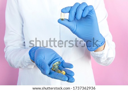 A doctor in latex gloves holds pills in her hands. Healthcare concept.