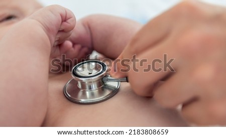 Doctor listens the heart to small newborn with stethoscope. Cute boy and chubby hands of a child. A newborn age of 3 months. Pediatrician's appointment, maternity concept