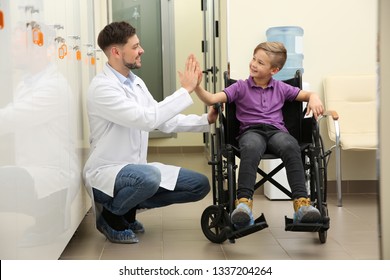 Doctor And Little Child In Wheelchair At Hospital