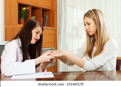 Doctor looking at  patient hands at table - Shutterstock ID 191445170
