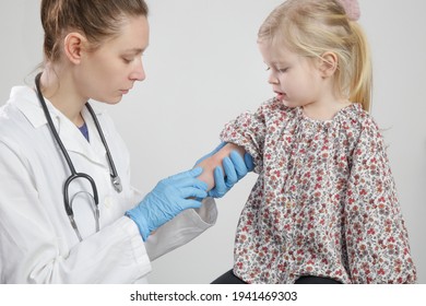 Doctor Looking At Red And Itchy Eczema On Little Girl's Arm. Toddler Girl Suffering From Atopic Dermatitis.