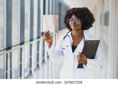 Doctor Looking Shoulder X-ray Film In Hospital. Radiography Concept. Radiology Female Doctor Examining X Ray Film Of Patient At Hospital Room.