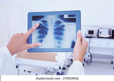 Doctor Looking At Xray On Tablet Against Empty Bed In The Hospital Room