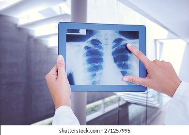 Doctor Looking At Xray On Tablet Against Stylish Modern Home Interior With Staircase