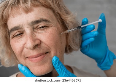Doctor makes beauty injections in the face of an old caucasian woman.  - Shutterstock ID 2364468695
