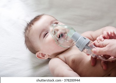 Doctor makes inhalation to a sick little baby. Healthcare and medicine concept at pediatrician department.