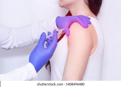 Doctor makes an injection of blockade of chondroprotector and anti-inflammatory drug in the girl's sore shoulder, white background, close-up, ozone therapy - Shutterstock ID 1408496480