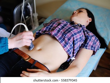 Doctor makes the patient women abdominal ultrasound. Pregnancy. Ultrasound Scanner in the hands of a doctor. Diagnostics. Sonography. - Powered by Shutterstock