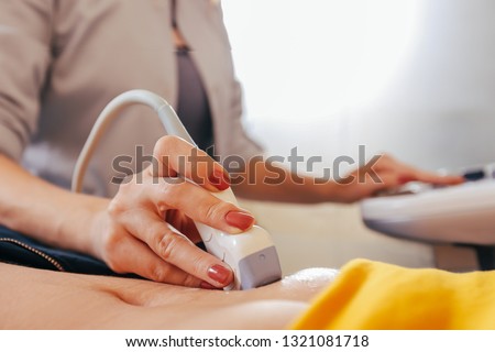 Doctor makes the patient women abdominal ultrasound. Ultrasound Scanner in the hands of a doctor. Diagnostics. Sonography 