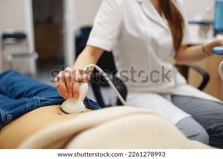 Doctor makes the patient women abdominal ultrasound. Ultrasound Scanner in the hands of a doctor. Diagnostics. Sonography. Pregnancy.