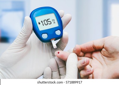 Doctor making blood sugar test in clinic for diabetes. 