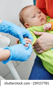 Doctor Making Blood Test From Newborn Child Finger Patient In Hospital