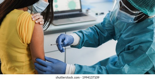 Doctor Making An Covid 19 Vaccine Injection To Female Patient - Focus On Doctor Right Hand