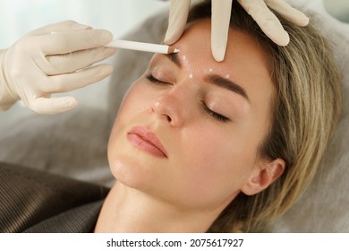 Doctor Making Marks On Client's Face Before Filler Injections In Aesthetics Medical Clinic