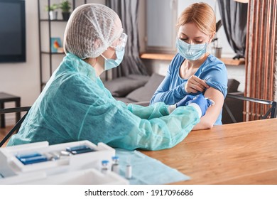 Doctor making vaccination to blonde woman patient while discussing something. Flu vaccination injection on arm, coronavirus, covid-19 vaccine disease preparing for human clinical trials vaccination - Powered by Shutterstock