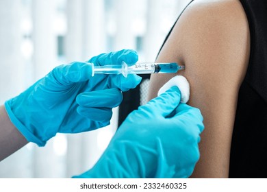 Doctor making a vaccination into patient with needle getting immune vaccine at arm for flu shot, coronavirus protective of epidemic.