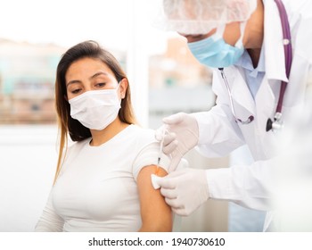 Doctor Male Giving Covid-19 Or Flu Antivirus Vaccine Shot To Female Patient At Health Clinic Or Hospital Office