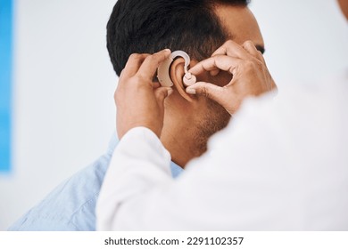 Doctor, man and hearing aid on ear for medical support, wellness and innovation of disability. Closeup, healthcare worker and deaf patient with audiology implant, service and help for sound waves - Powered by Shutterstock